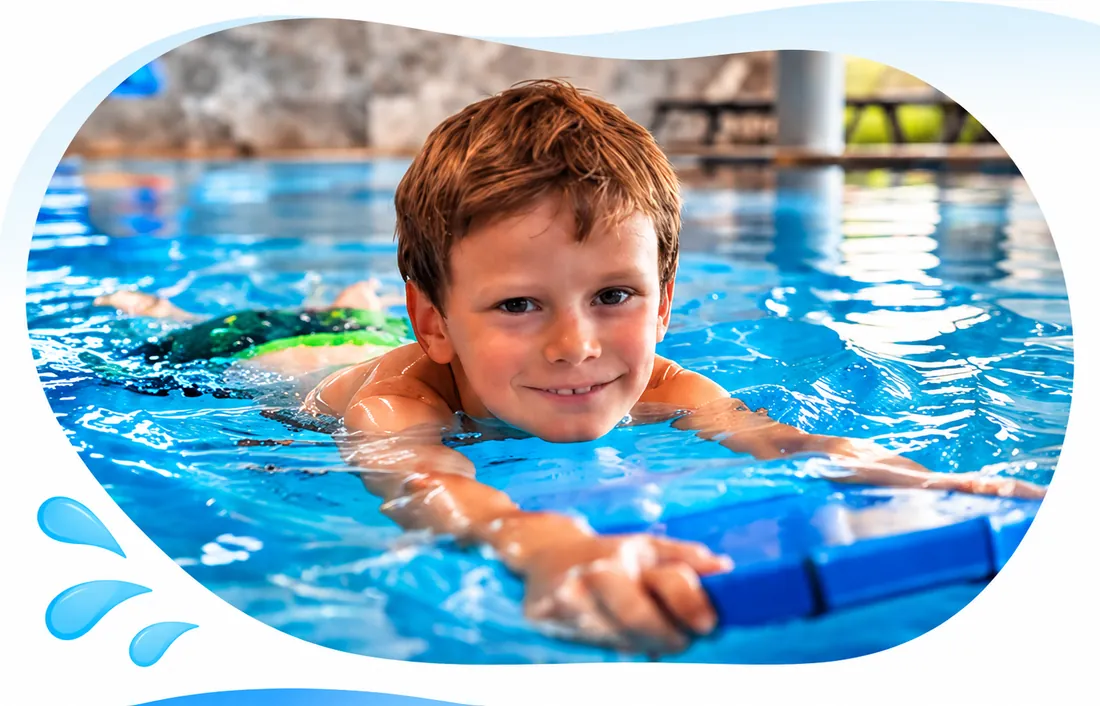 Junge schwimmt mit einem Schwimmbrett im Hallenbad